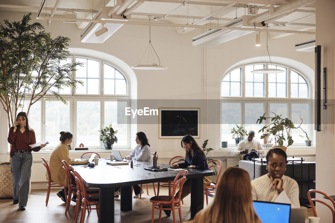 Multiracial team of male and female business professionals working at coworking office