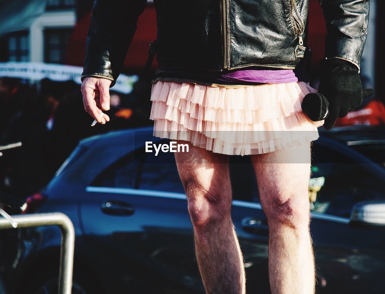 Low section of man wearing mini skirt while standing on road