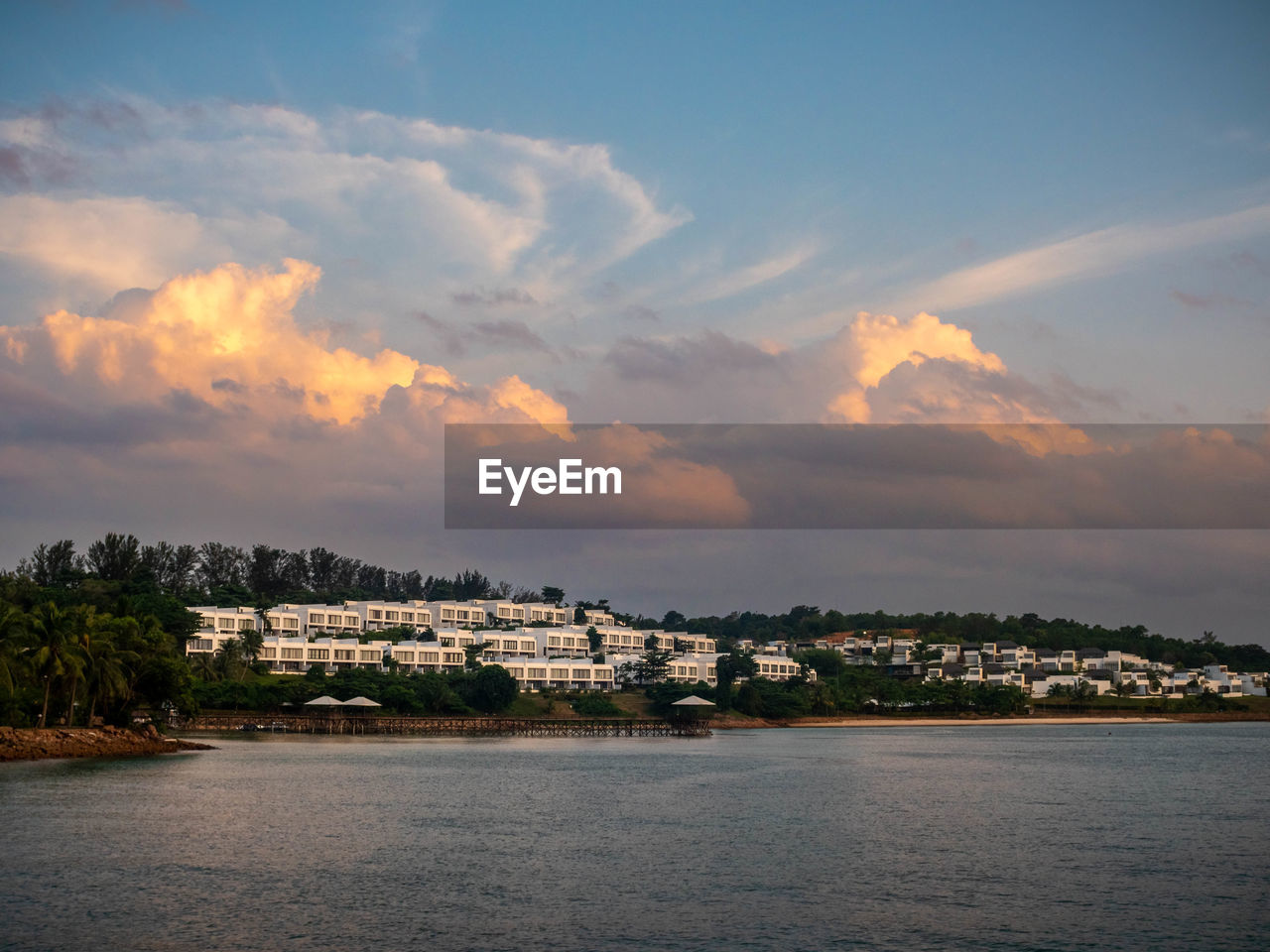 Scenic view of sea and resorts against sky during sunset