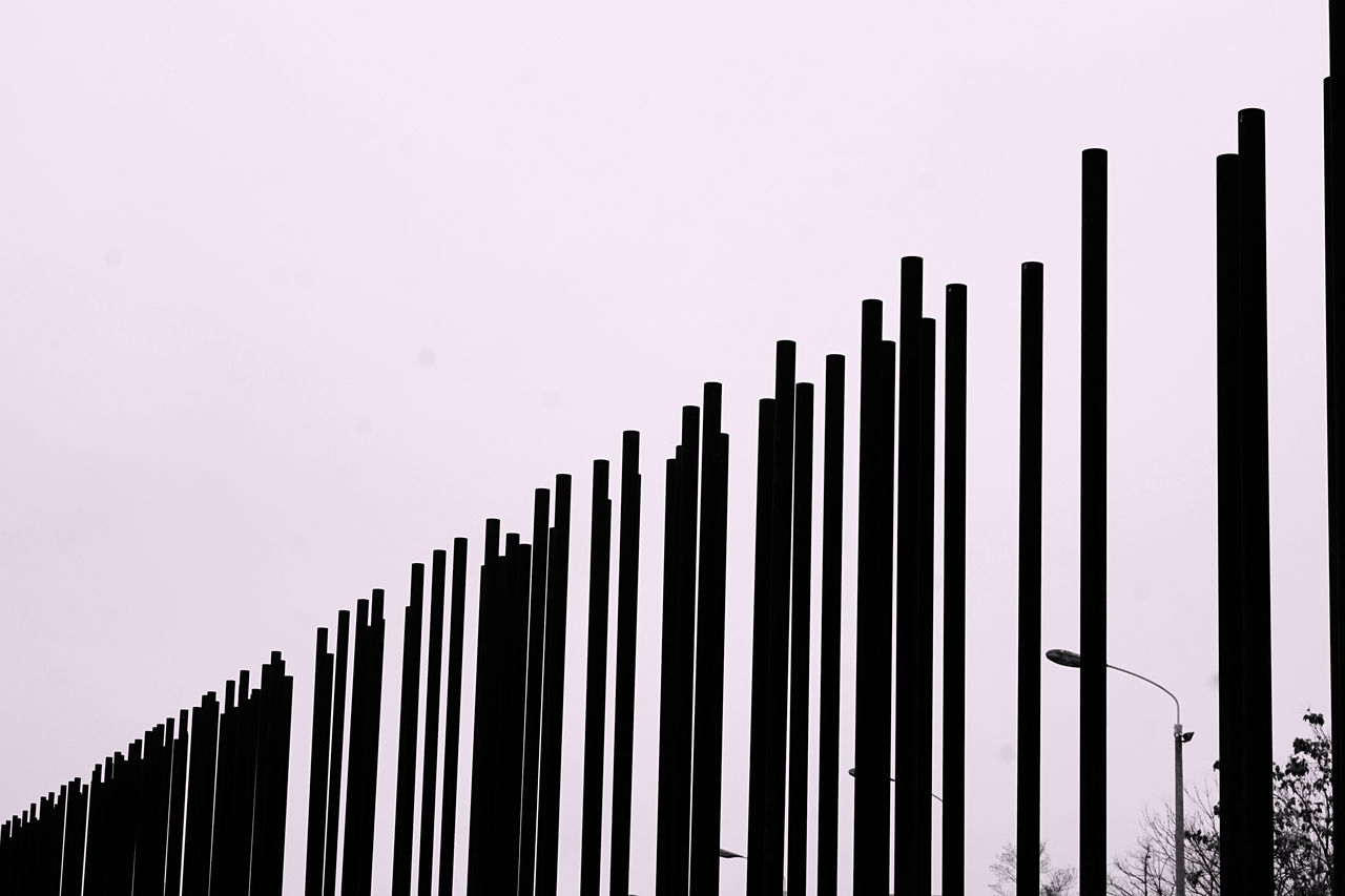 Close-up of silhouette poles against clear sky