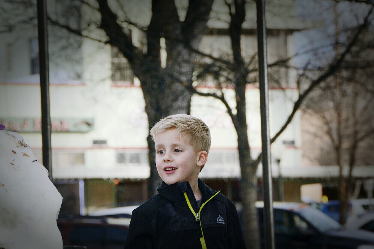 Boy looking away at sidewalk