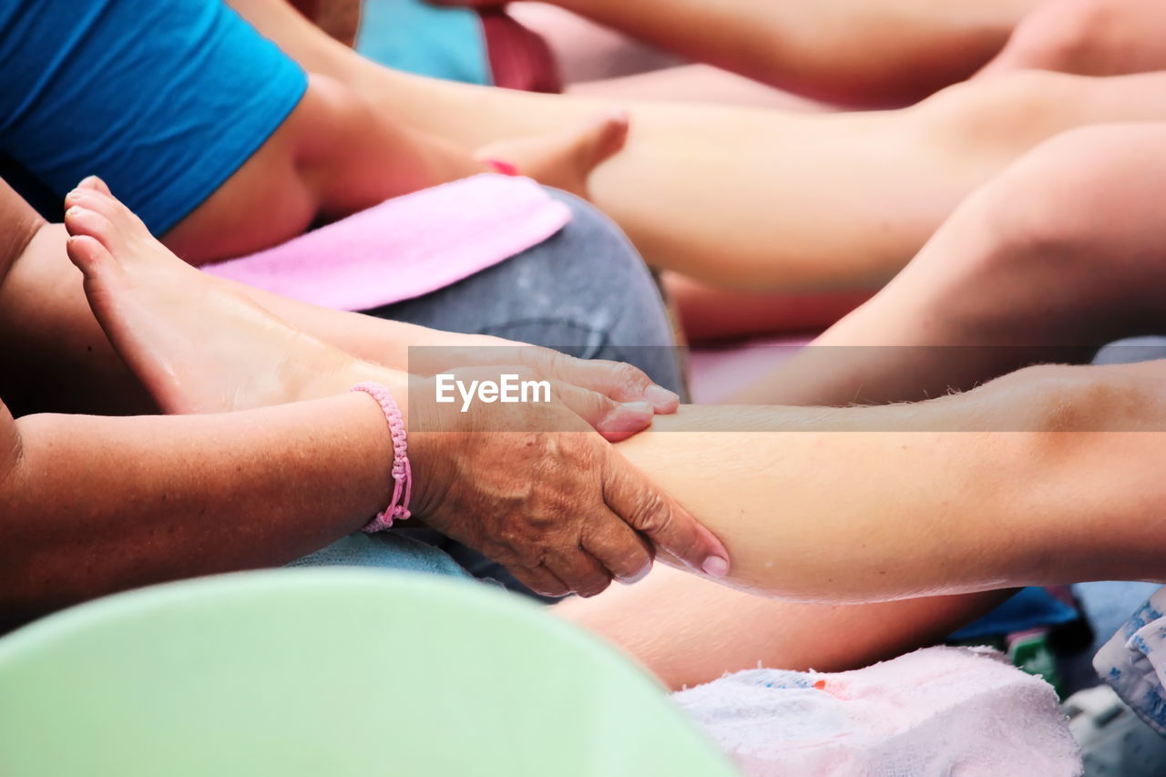 MIDSECTION OF PEOPLE HANDS ON BABY