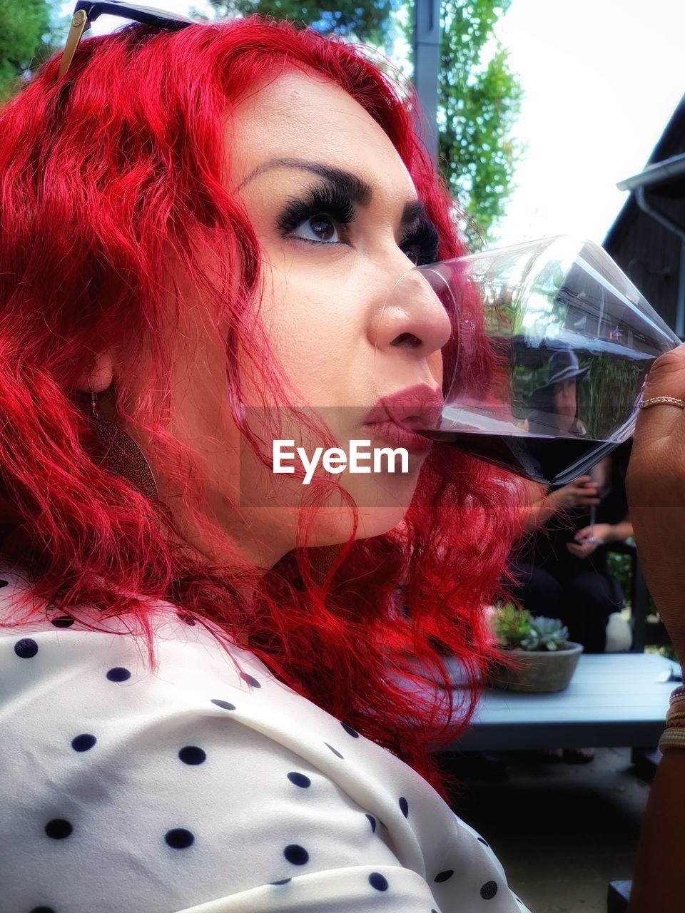 CLOSE-UP PORTRAIT OF A YOUNG WOMAN WITH RED DRINK