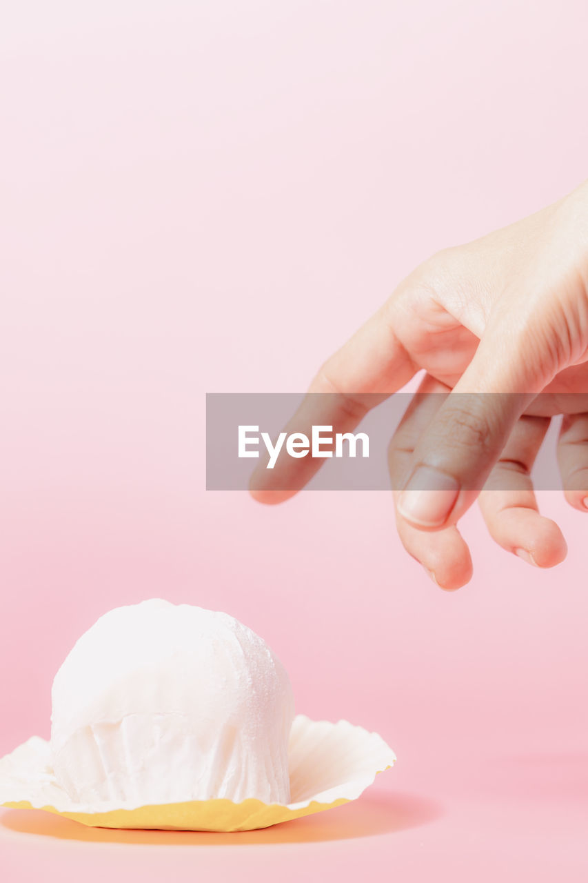 Hand reaching out to pick a delicious strawberry daifuku, japanese rice cake up