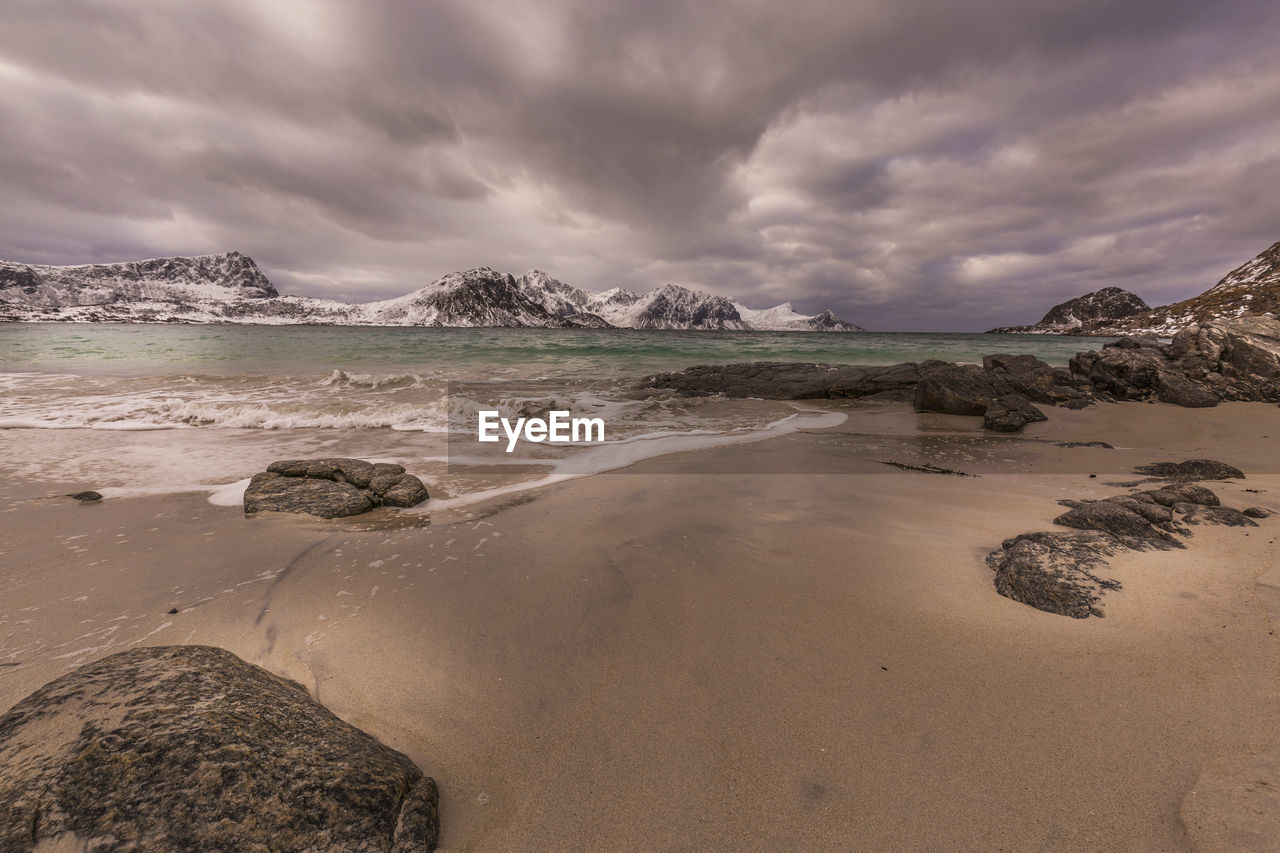 SCENIC VIEW OF BEACH AND MOUNTAINS AGAINST SKY