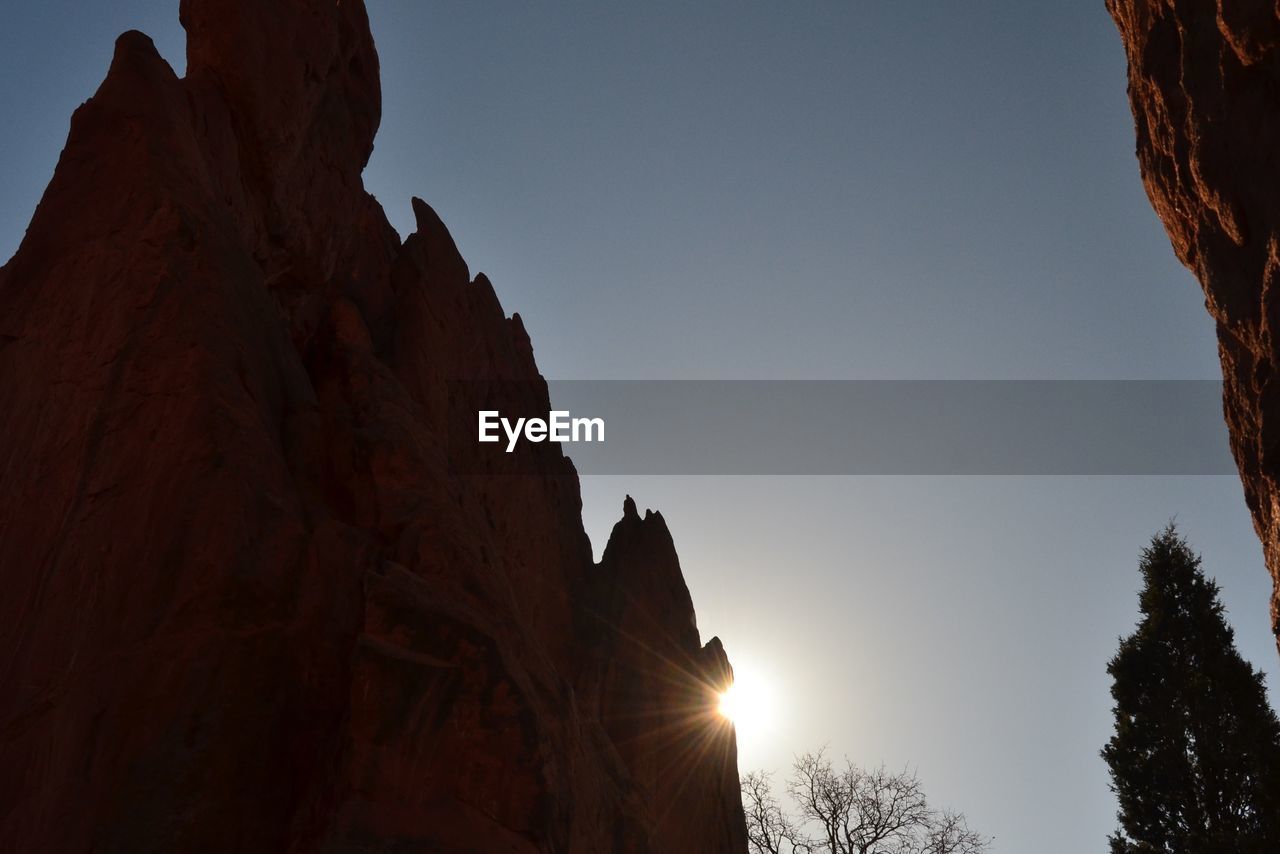 LOW ANGLE VIEW OF SILHOUETTE ROCKS AGAINST SKY