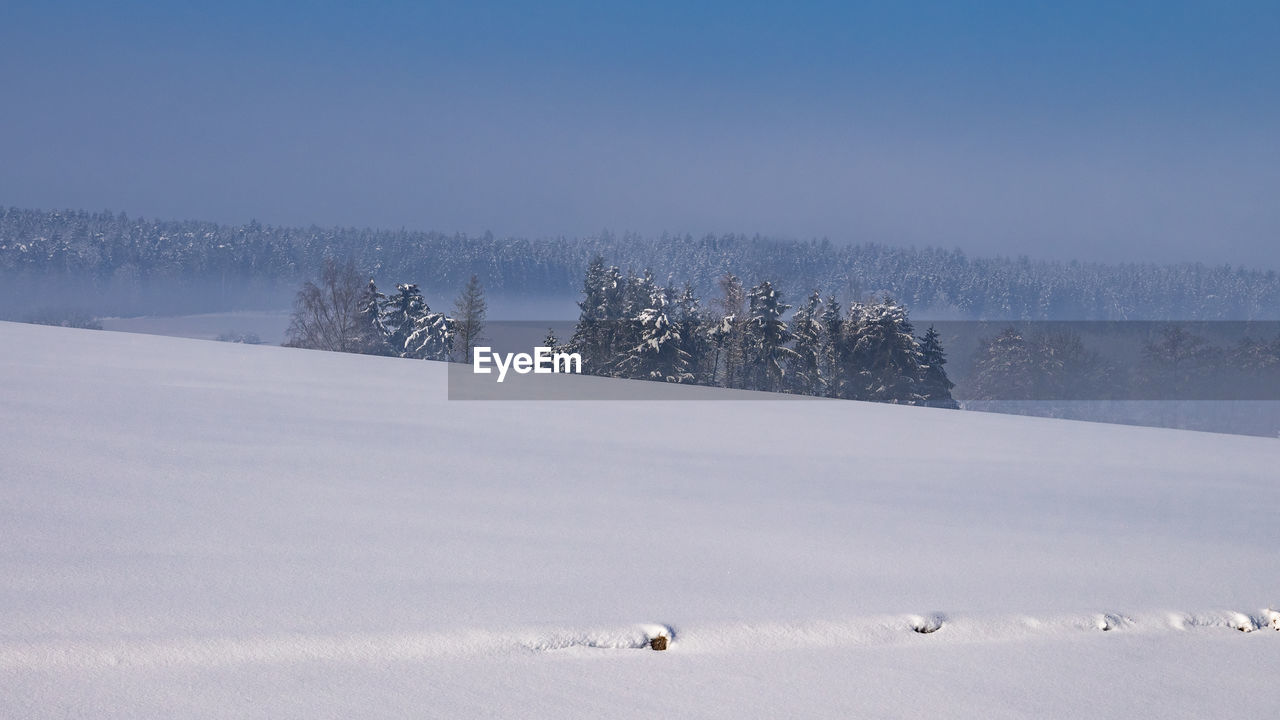 Scenic view of snow covered field against sky