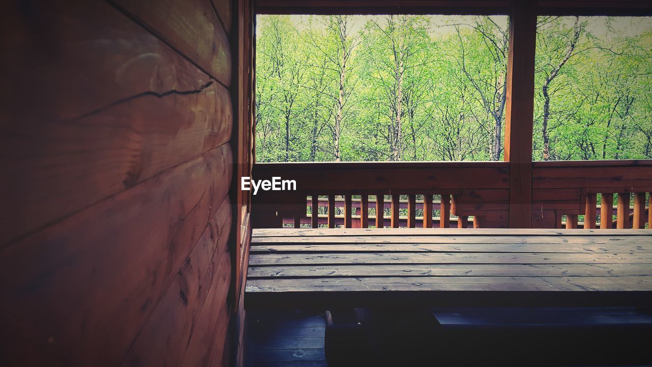 Wooden table in balcony against forest
