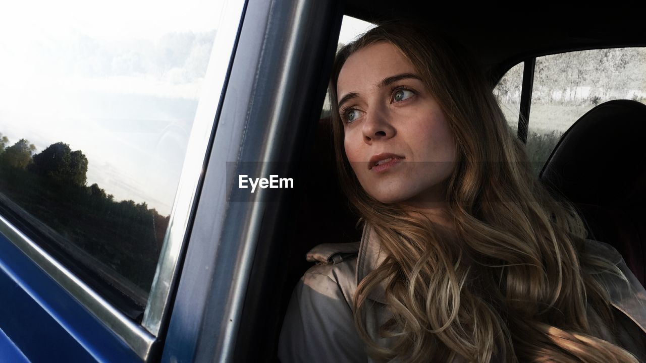 PORTRAIT OF WOMAN IN CAR