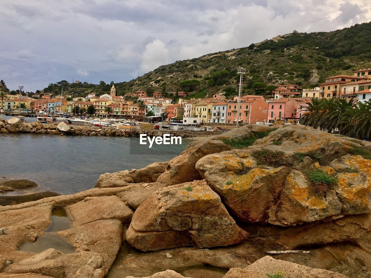 Scenic view of sea by townscape against sky