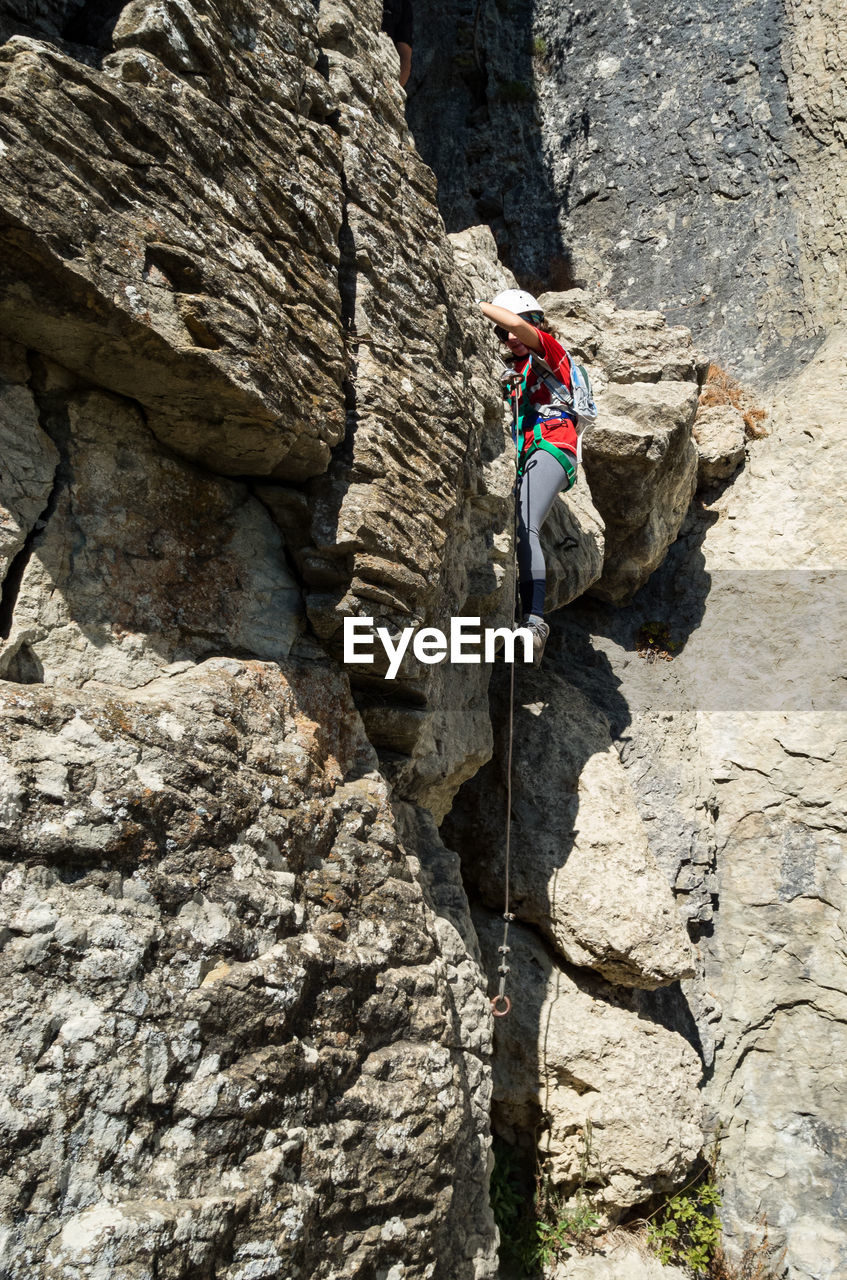 Side view of woman climbing mountain