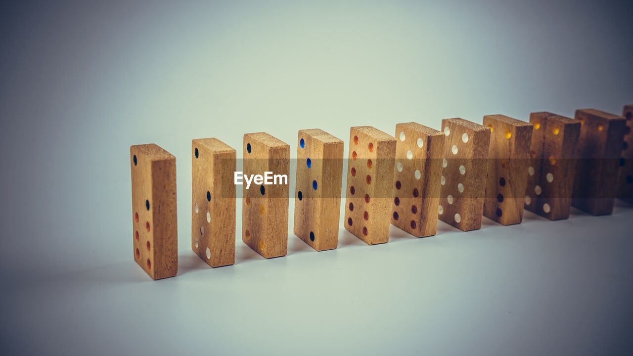 Close-up of dominoes in a row against blue background