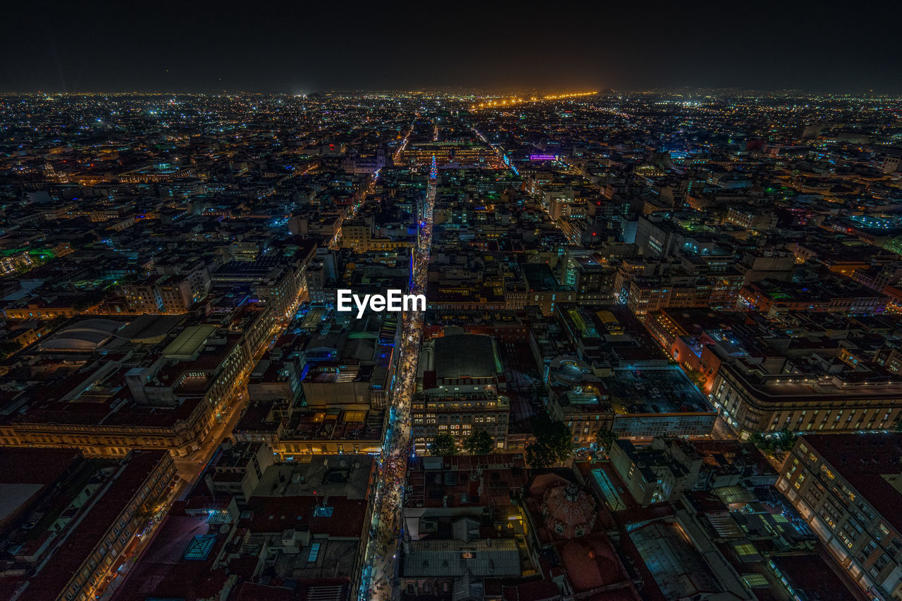 Illuminated city against sky at night