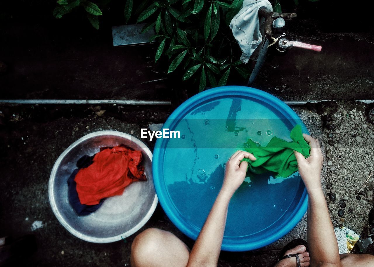 LOW SECTION OF BOY HOLDING BOWL IN BACKYARD