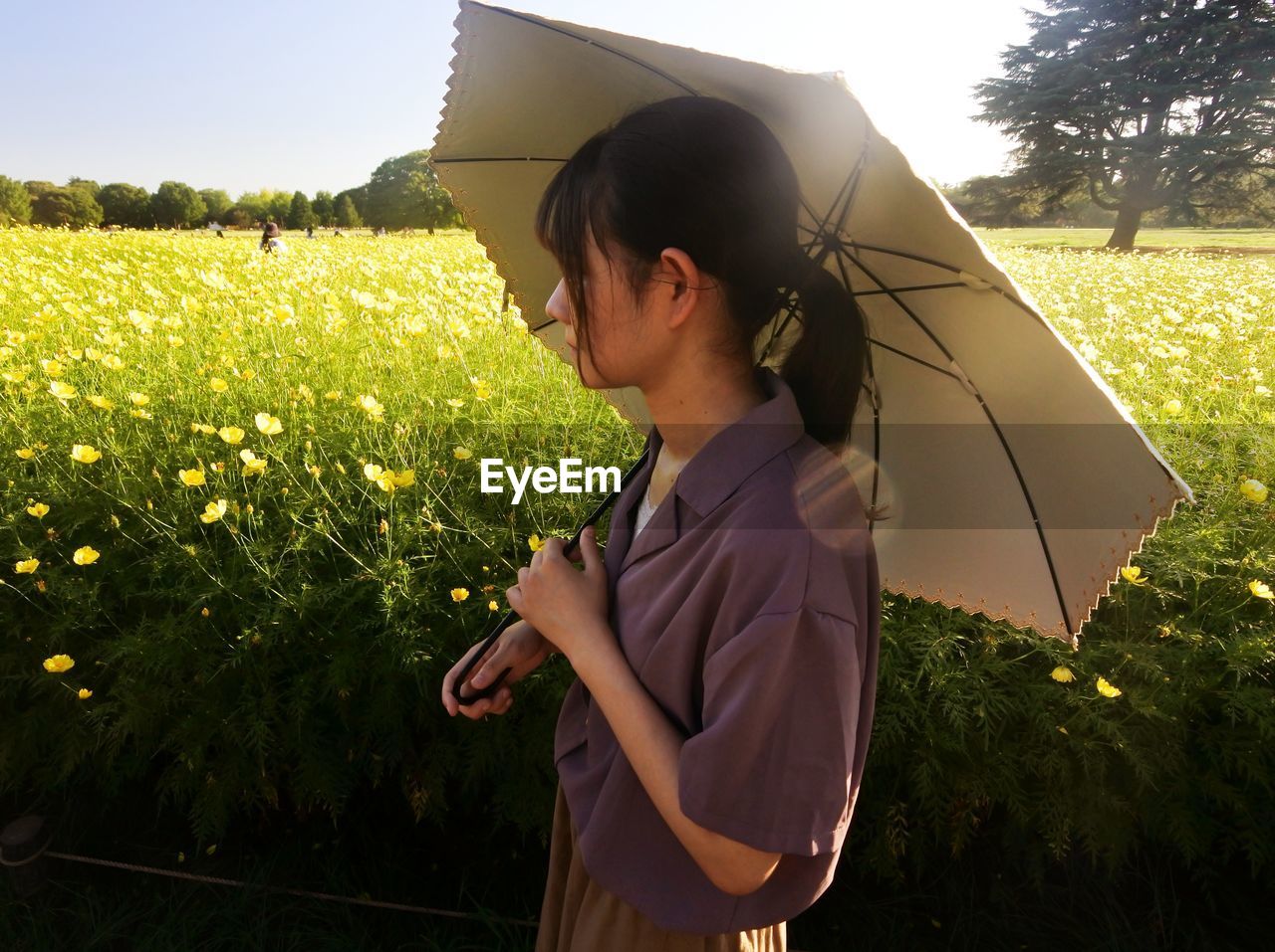 Side view of young woman standing on field