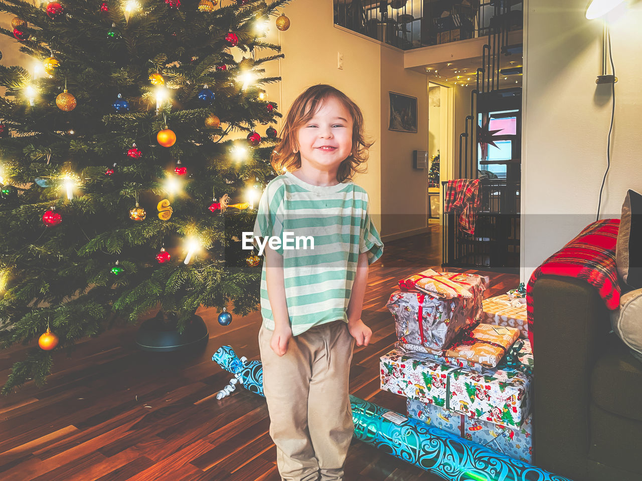 Portrait of boy standing by christmas tree