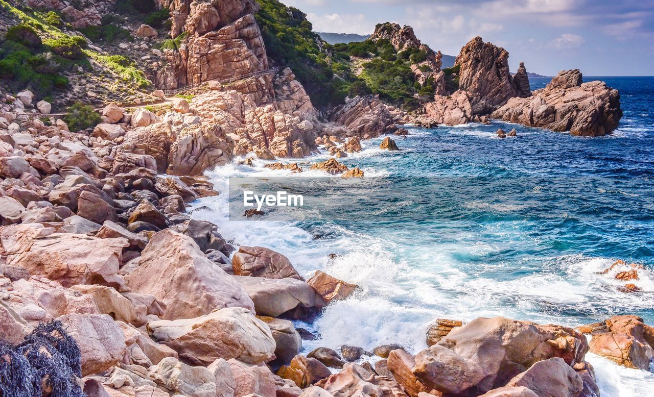 Rock formation in sea against sky