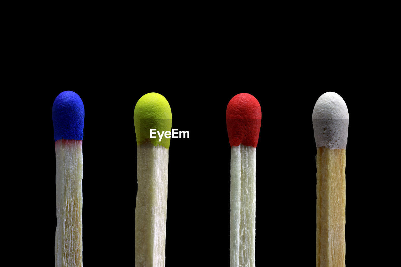 Close-up of multi colored matchsticks against black background