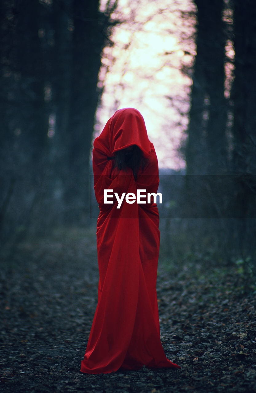 Person in red cloak in forest