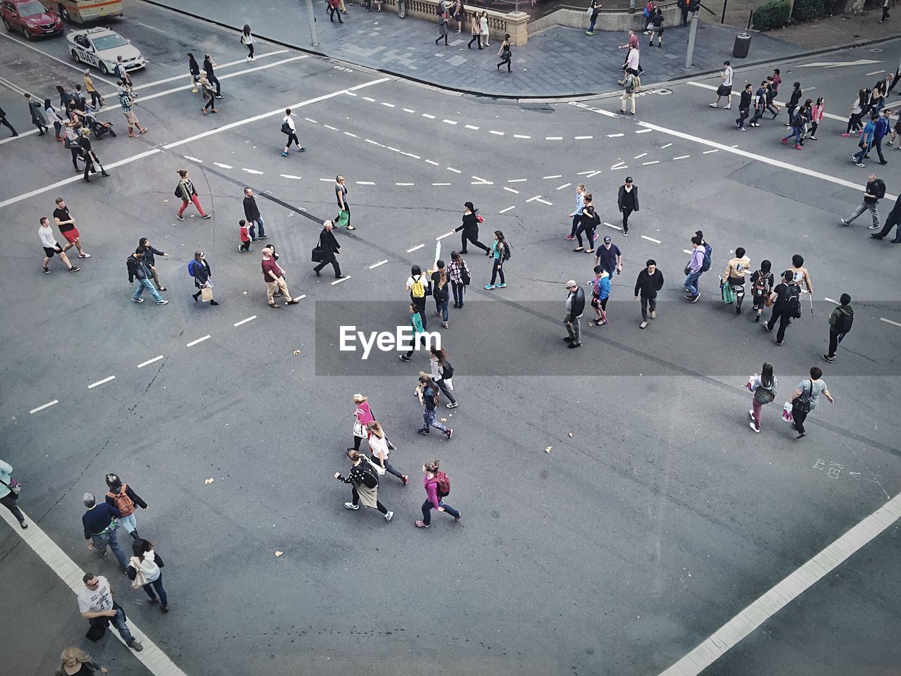 PEOPLE WALKING ON ROAD IN CITY