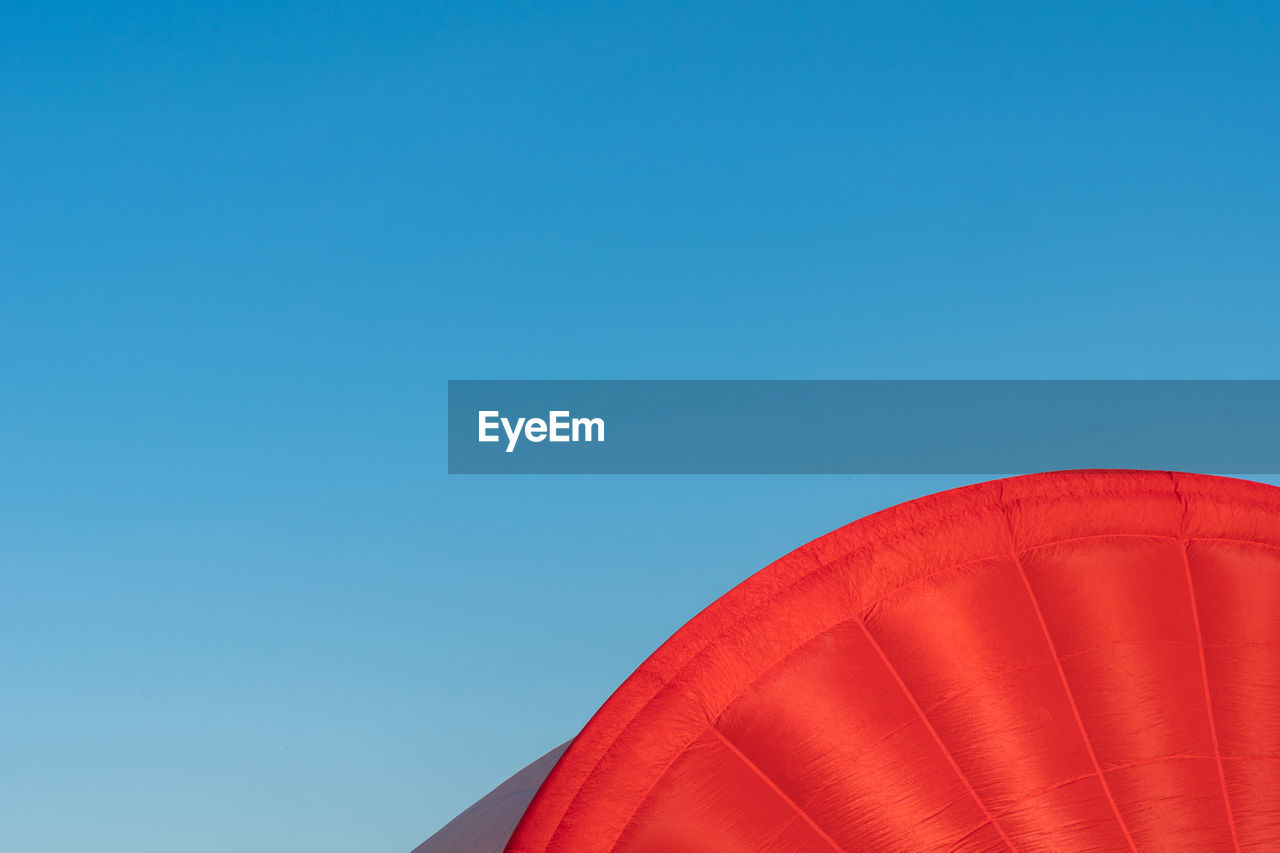 Low angle view of red hot air balloon against blue sky