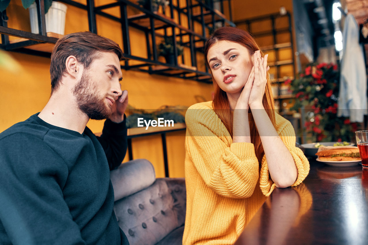 Young couple sitting on table at restaurant