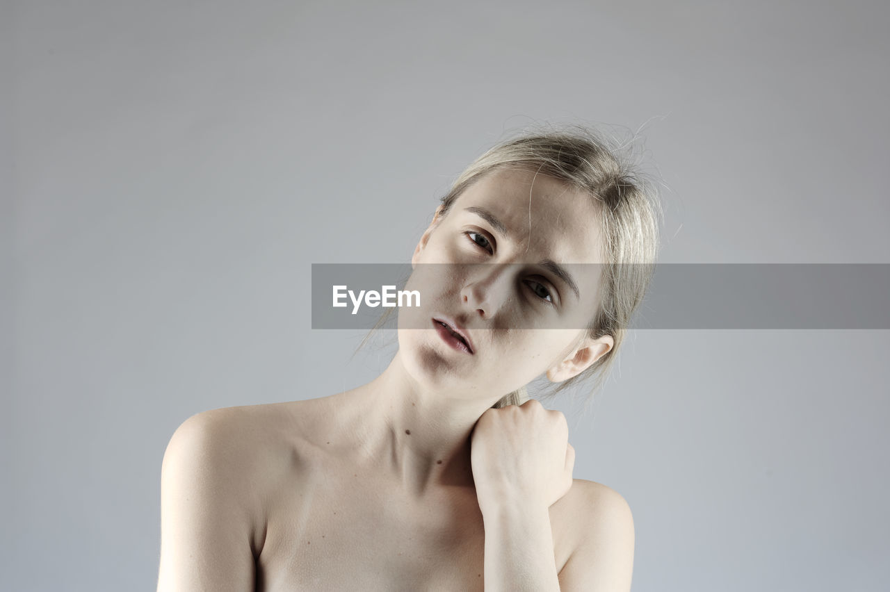 Portrait of young woman against white background