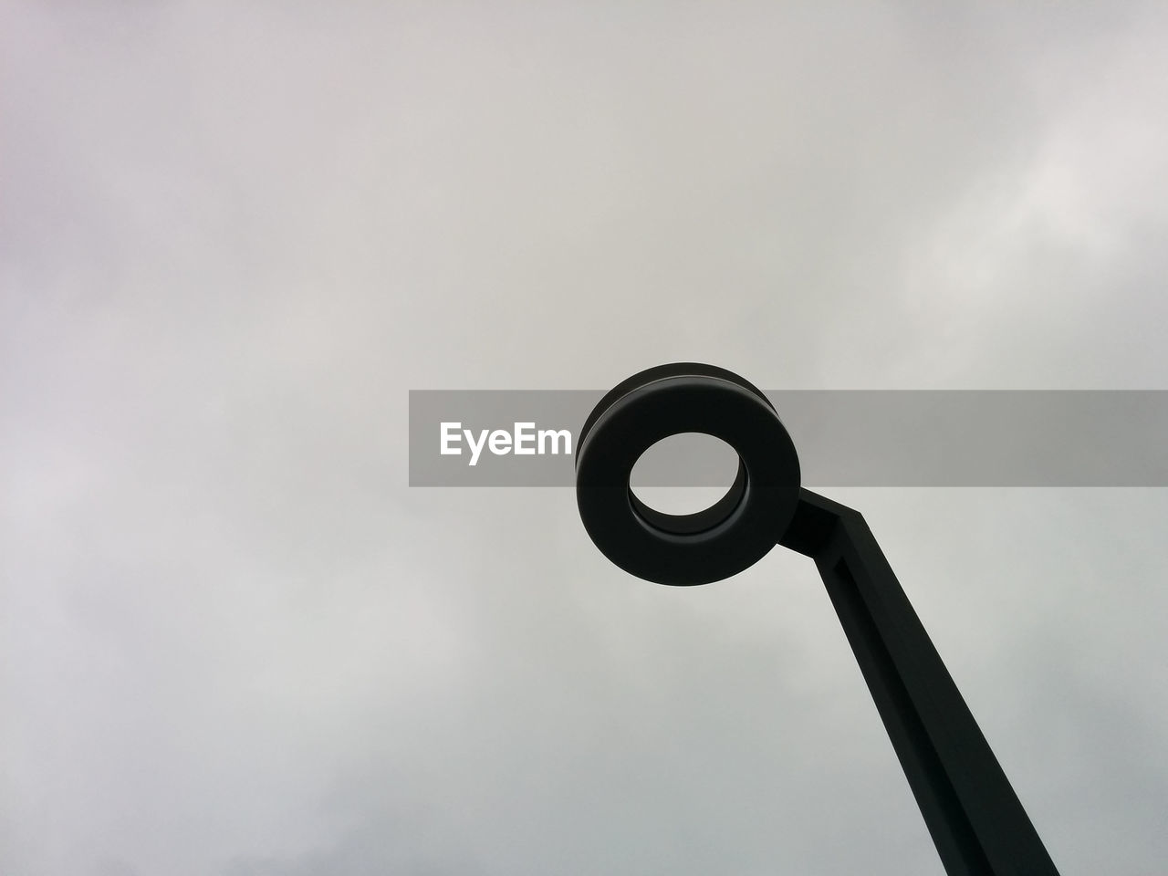 Low angle view of lamp post against cloudy sky
