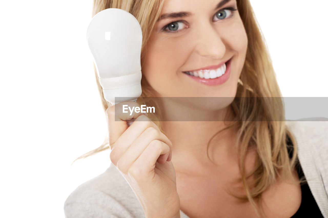 Woman holding equipment during pregnancy test against white background