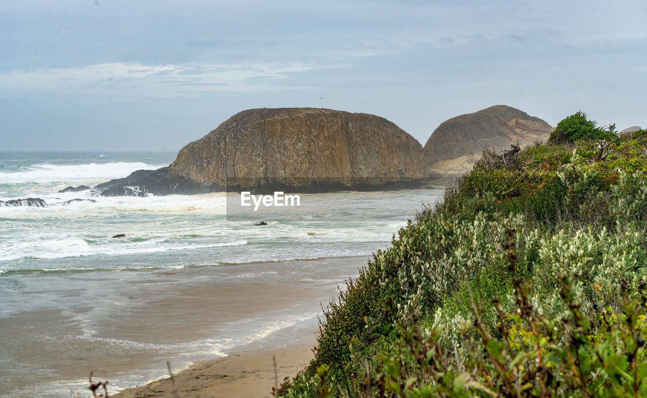 A view of a land formation in the sea on arainy day in oregon state.