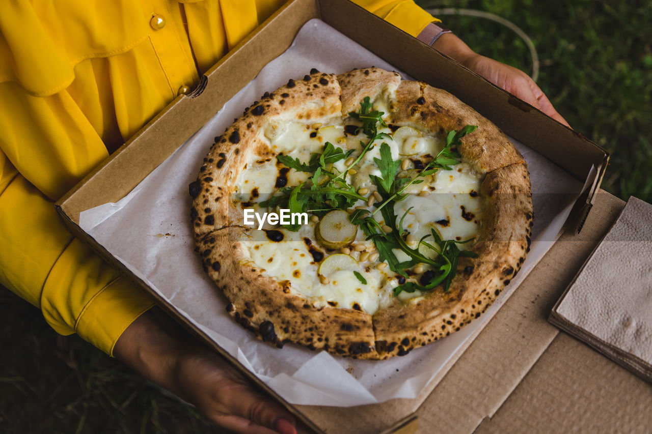 High angle view of hand holding pizza