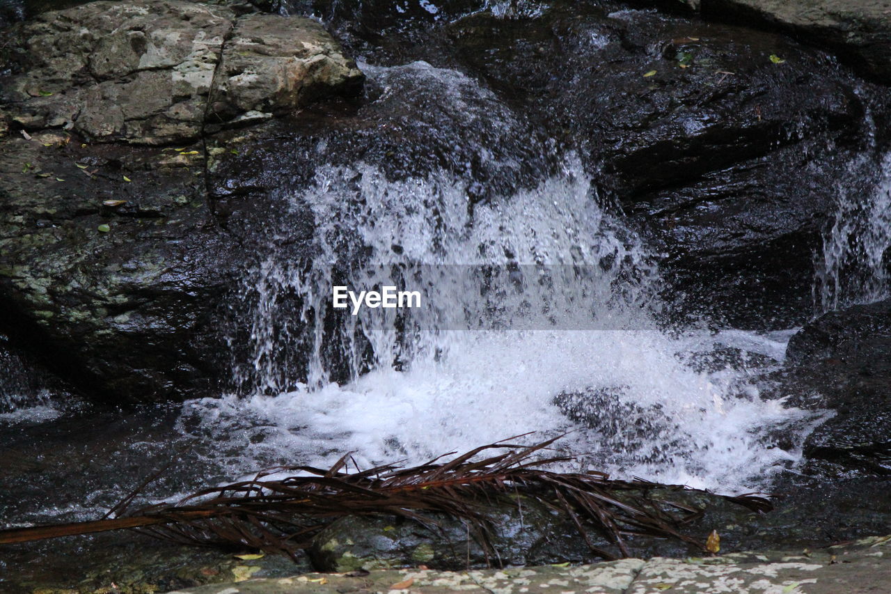 SCENIC VIEW OF WATERFALL IN ROCKS