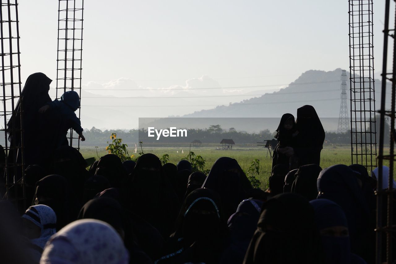 Women wearing burkhas standing on field