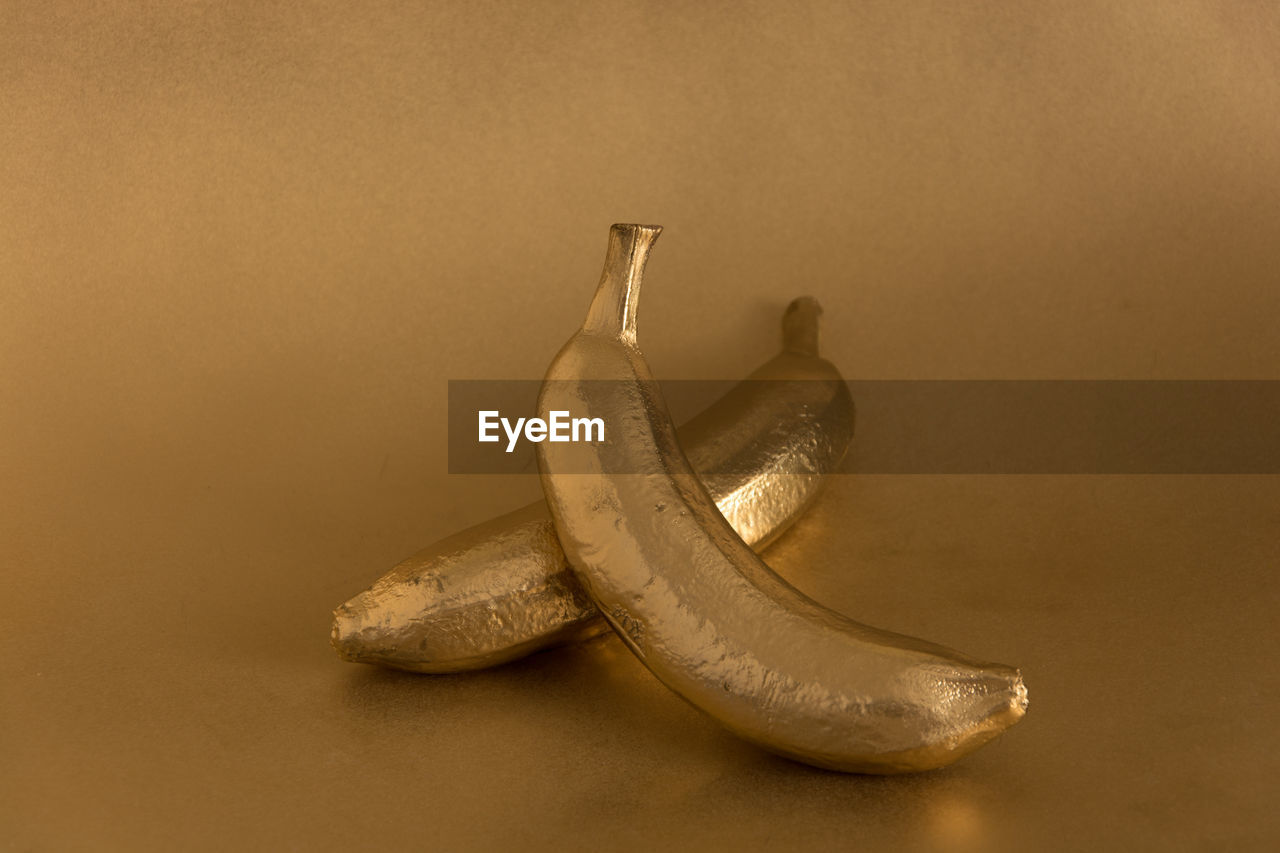 Whole golden banana on a golden background
