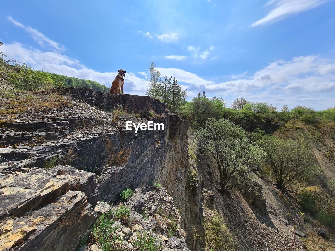 LOW ANGLE VIEW OF PEOPLE ON ROCKS AGAINST SKY