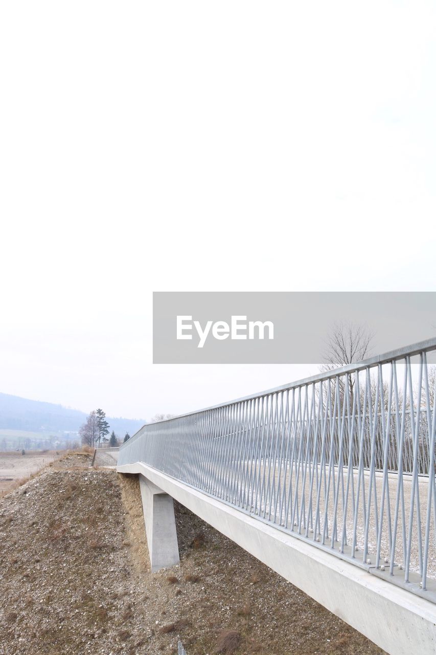 Railing on bridge against clear sky