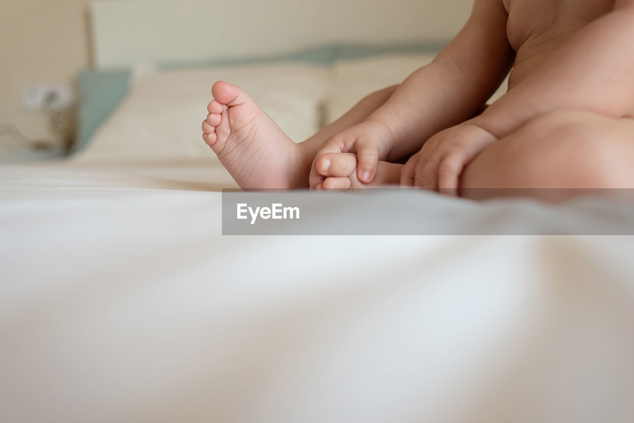 Unrecognizable baby boy lying on bed, close up