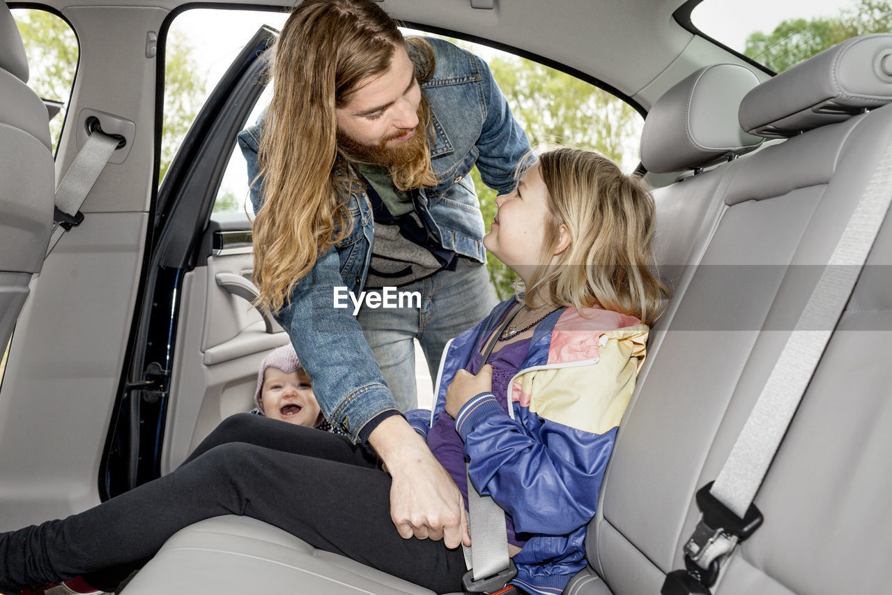 Father checking daughters safety belt