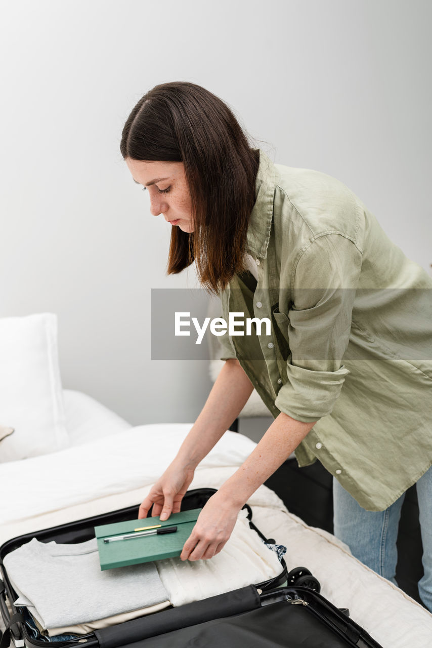 Young brunette woman packing a suitcase for a summer holiday abroad. summer. traveling overseas.