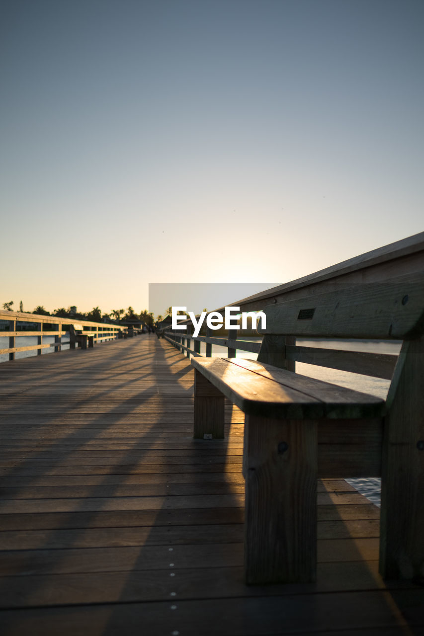 View of empty bridge against clear sky at sunset