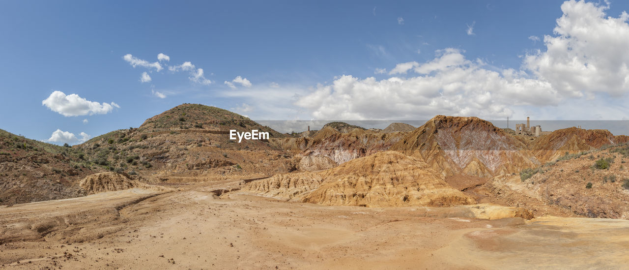 PANORAMIC VIEW OF ARID LANDSCAPE AND MOUNTAINS AGAINST SKY