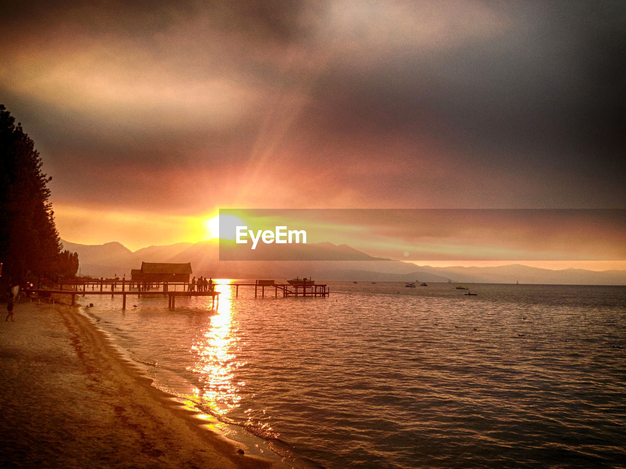 Jetty in sea against sunset sky