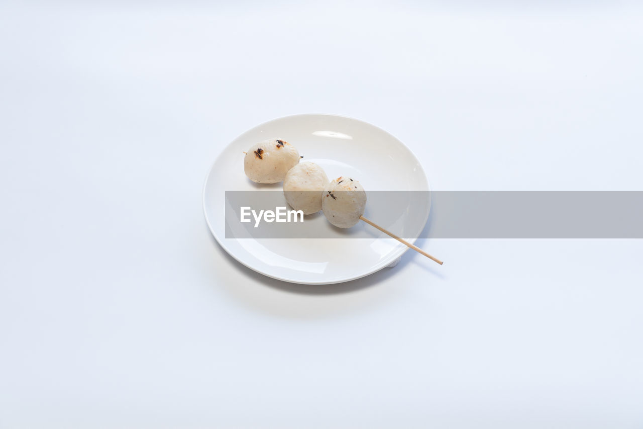 food and drink, studio shot, food, indoors, white background, plate, copy space, eating utensil, no people, kitchen utensil, white, high angle view, porcelain, spoon, lighting, freshness, sweet food, close-up, dairy, healthcare and medicine, wellbeing, sweet