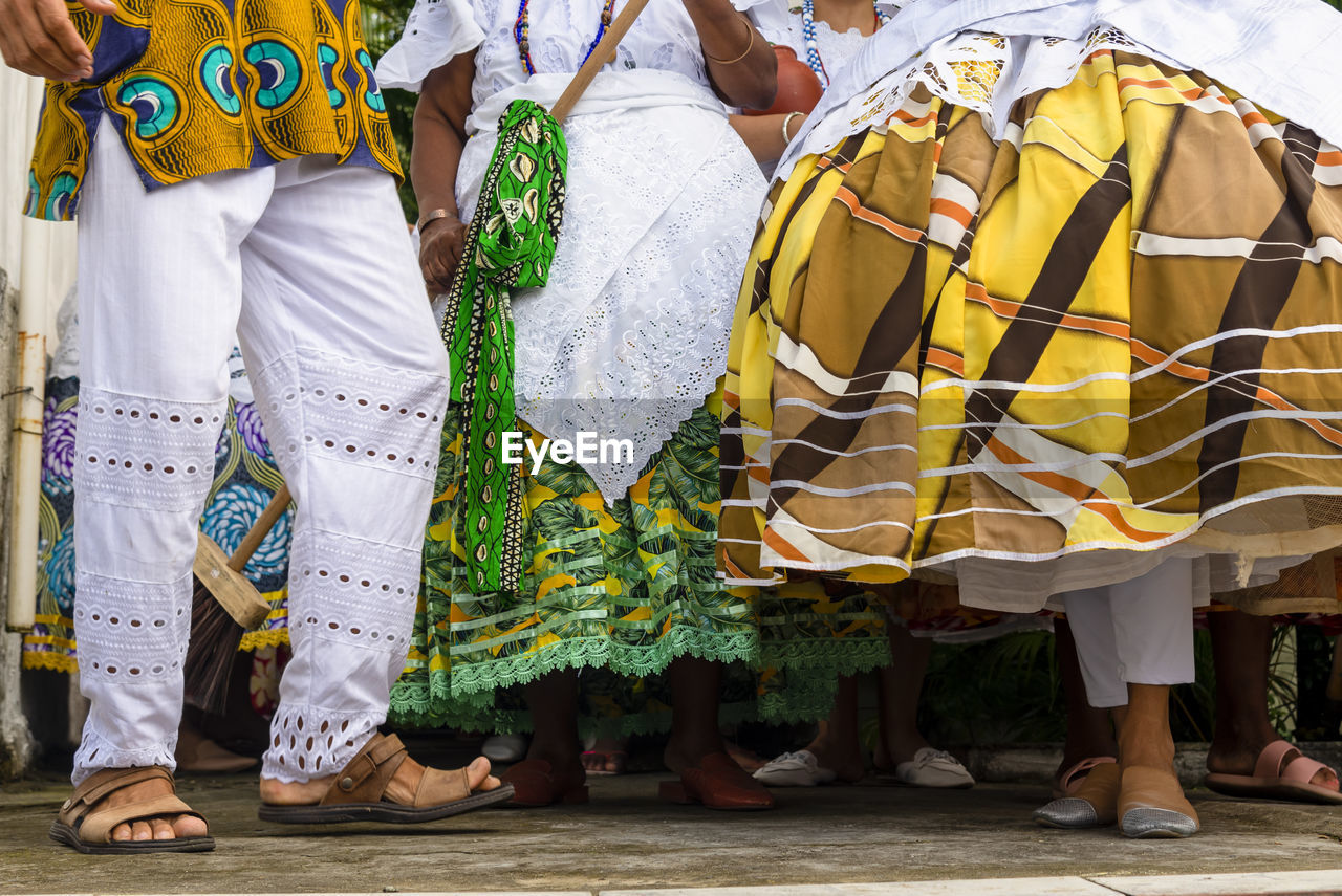 Lower part of candomble members dressed in traditional clothes for religious festival