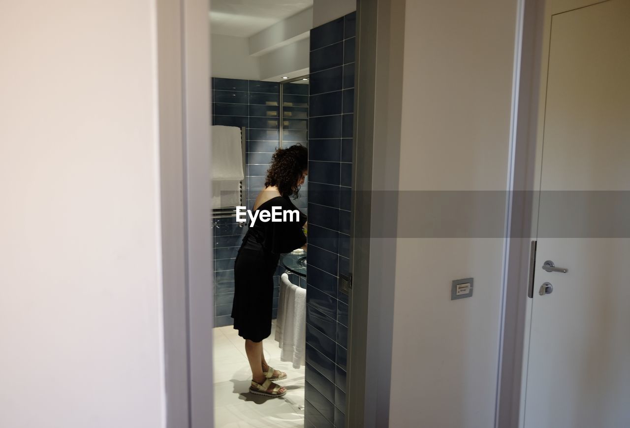 Side view of woman standing in bathroom