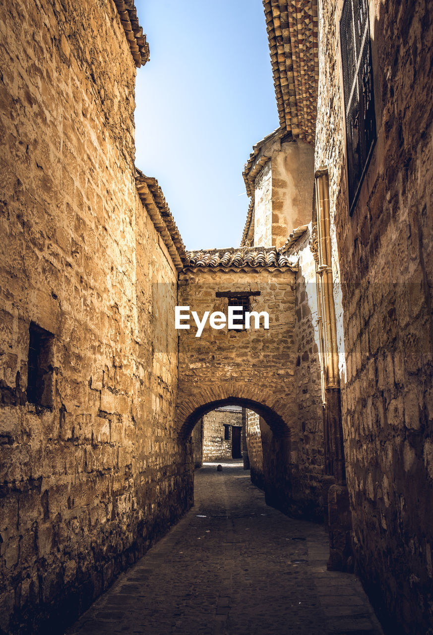 Narrow alley amidst buildings against sky