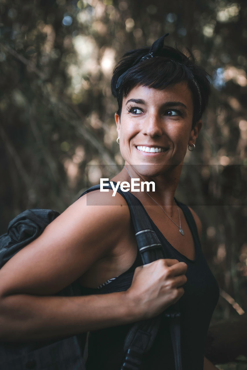 Smiling woman standing in forest