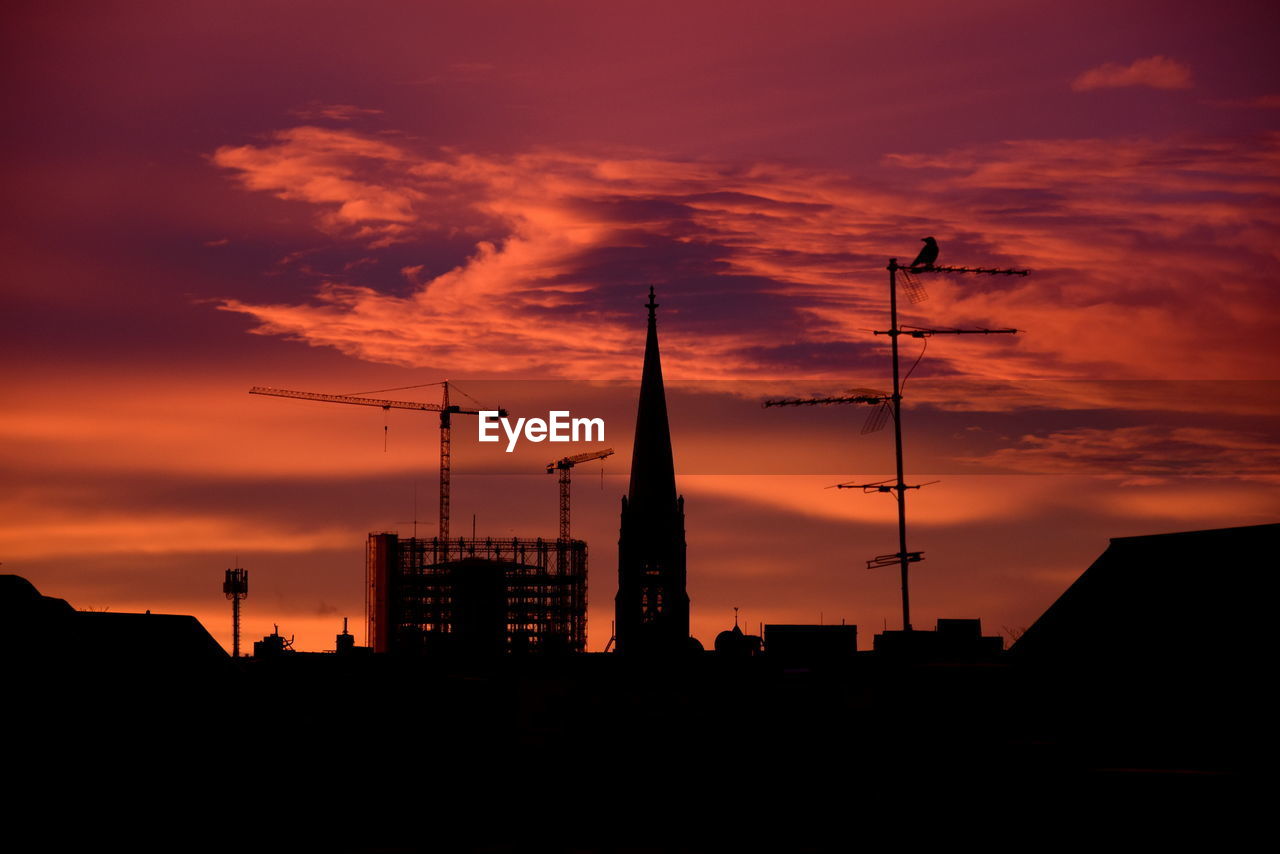 low angle view of silhouette buildings against sky during sunset