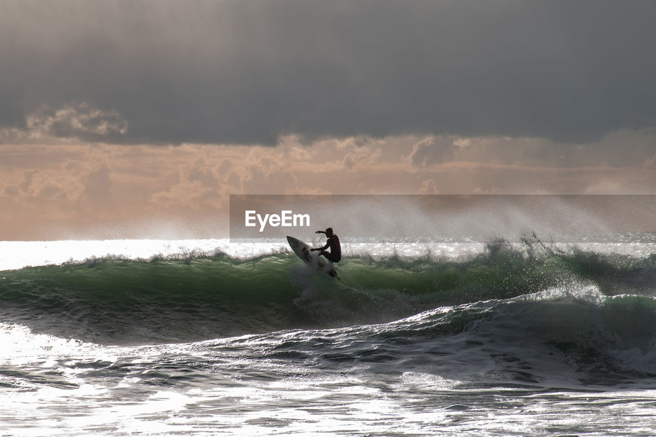 Man surfing in sea against sky