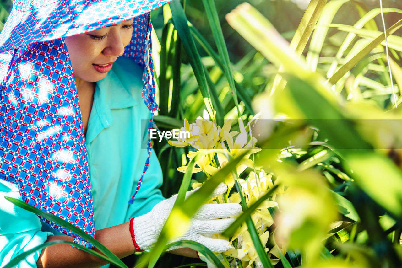 Female researcher examining plants in greenhouse